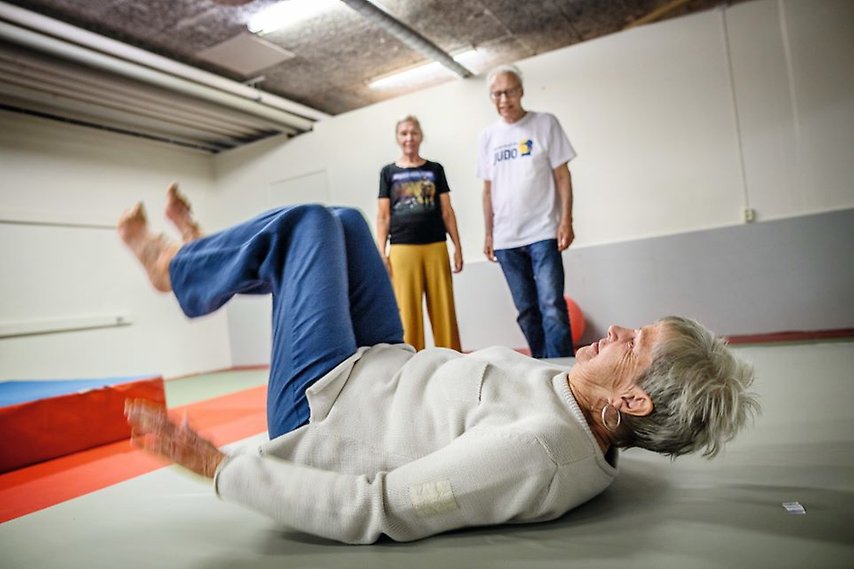 En äldre kvinna övar på fallträning på matta. Fotograf: Jenny Ingemarsson